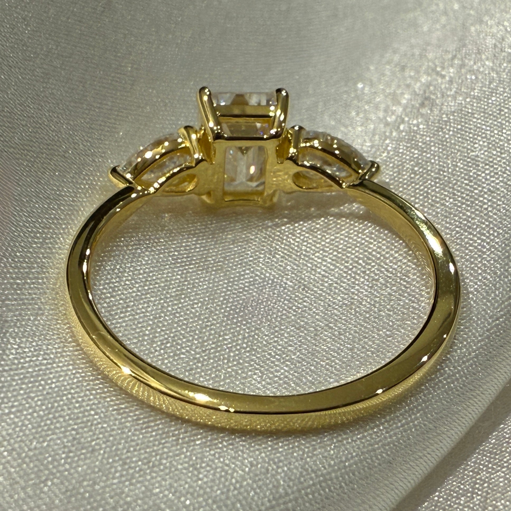 Gold ring with lab diamond on a light gray background