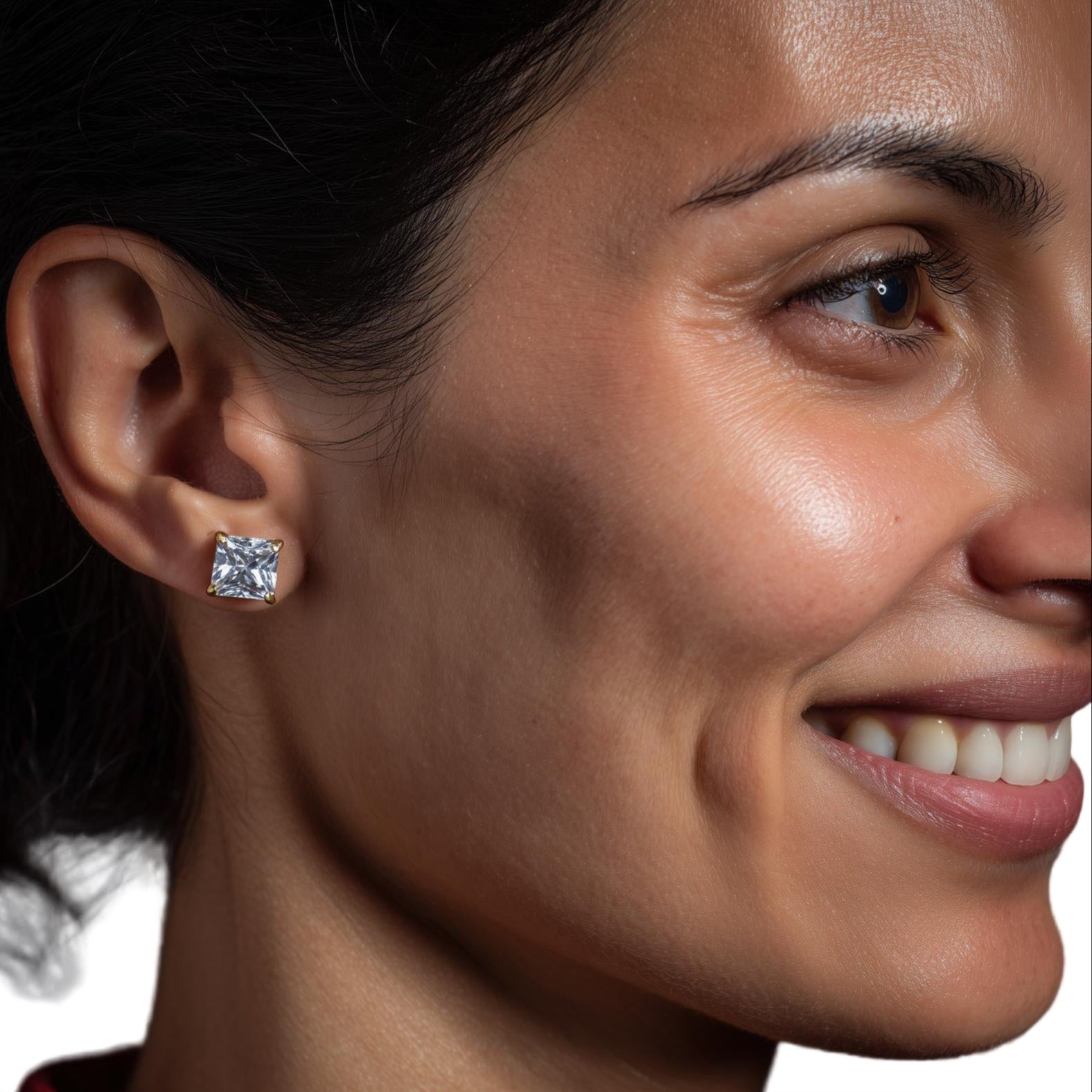 Close-up of a woman wearing diamond earrings with a dark background